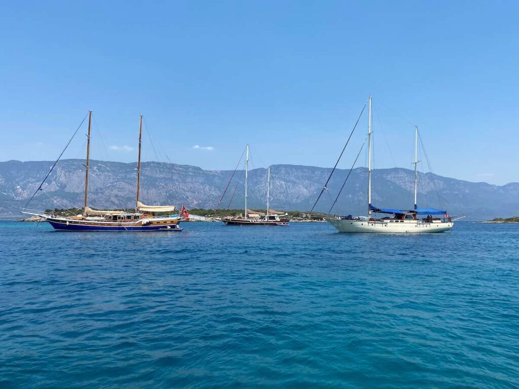 üç adet yat deniz kıyısında demir atmış